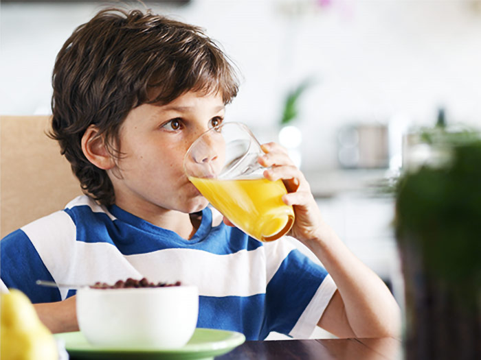 Junge trinkt ein Glas Orangensaft